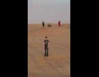 Brunette woman red dress jumps sand desert