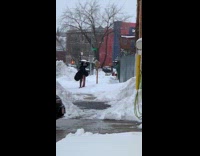 Person throws large wooden spoon onto snow 