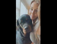 Girl kisses large black brown dog eyebrows 