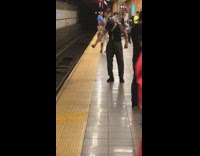 Old man puts hand into a fist and moves arm in front of him at the subway