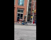 Collab WINY - Man ride bicycle balance trash can on head