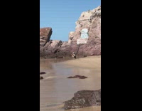 Guy jumps over leg beach white hat  