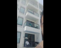 Woman in green beach dress tiktok dance at the balcony