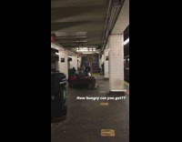 Guy sits with large wooden spoon sculpture 