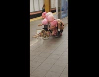 Guy wearing pink inflatable mask controls puppets 