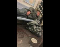 NSFW Sleeping man laying down on subway seat pulls down zipper and pees on the floor
