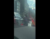 Clown juggling clubs in traffic