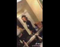 Two girls walk by mirror hotel bed 