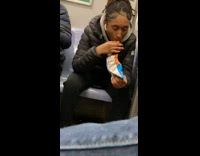 Woman wearing airpods sucks on her Cheeto puffs on subway train
