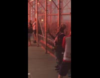 Soccer fans red shirts crowd on the street with fireworks smoke, chant song and clap hands