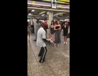 man dancing with toy doll in subway station
