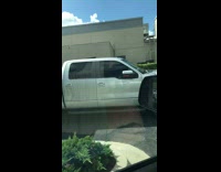 Passenger in white truck pumpkin head scarecrow