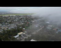 Drone shot over houses and streets cloudy sky
