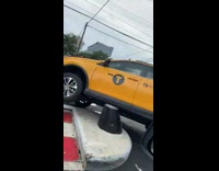 Taxi stuck tilted on barrier 