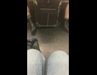 Man spreads legs wide open with luggage suitcase between legs on subway train