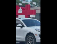 Woman in red dress with sunglasses poses at the gas station