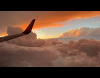 Airplane view of orange clouds sunset flight