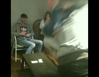 Guy wrestles girl, picks her up over his shoulders, and throws her onto a table