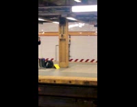 Guy on subway platform sings into microphone 