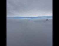 man hanging on ropes top of building