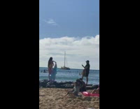 Girl stands on beach rocks for photo