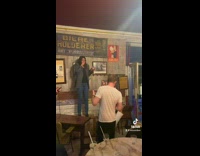 Woman dancing on table desk falls over in bar