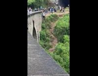 Man hangs on the side of the bridge