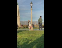 Girl hold lamp pole fever pose park