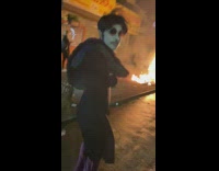 Man dances and does split in front of street fire