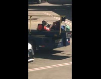 Worker lays on luggage conveyor belt with orange cone at airport on his break
