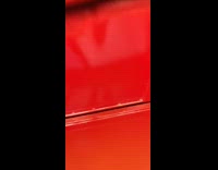 Guy inside of red clothes donation bin 