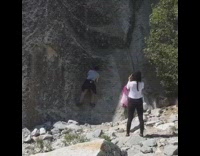Guy climbs giant rock for photo 