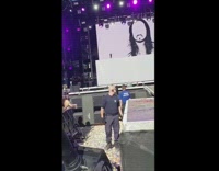 Guy holding cake me sign gets caked in the face by Steve Aoki at a concert