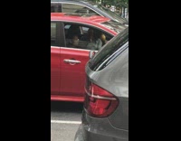 Man dances with yellows maracas while driving in red car salsa music