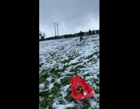 Guy scooters down snowy hill with butt out 