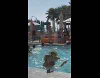 Woman blue bikini dance crowded swimming pool