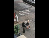 Two women do sexy dance recital in the middle of street, car passes