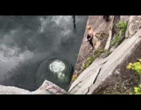 Black wetsuit guy double backflip grey water