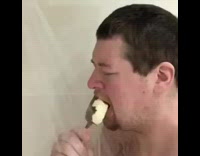 Guy eats ice cream bar in shower
