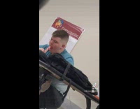 Guy blue shirt eating candy cane in class on desk 
