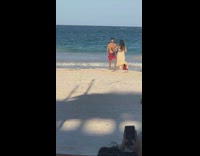 Man in red shorts jumps for a jump shot on the beach