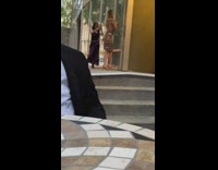 Woman in dress poses against the wall