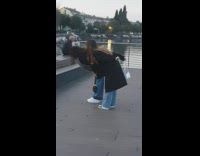 Two girls black coat hold bag river