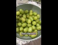 Woman amused with huge grapes she bought