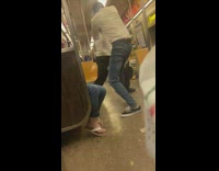 Two guys wearing white shirts on the subway train fighting
