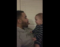 Baby boy sticks tongue out with dad 