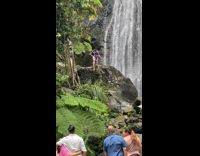 Collab IITW - Man pose near the waterfalls while tourists watch from the bridge