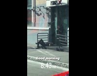 Store owner waking up man sleeping in store front 