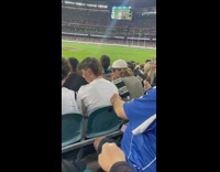 Girl starts shoulder tap train at baseball game 