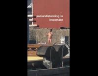 Pink speedo guy dances rooftop red building 